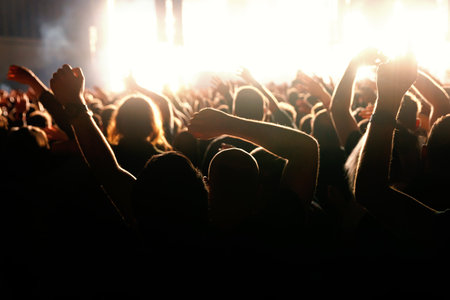 Happy people crowd with raised hands on a dance floor during a concert
