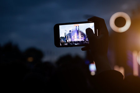 People at concert shooting video or photo using mobile phones.の写真素材