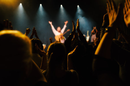 Enthusiastic crowd captivated by electrifying live performance under vibrant lighting.の写真素材