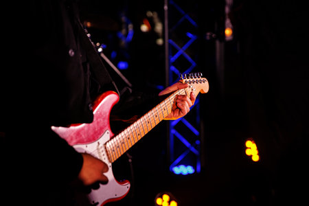 Close-up of guitarist hands playing the guitar at the live music festival.