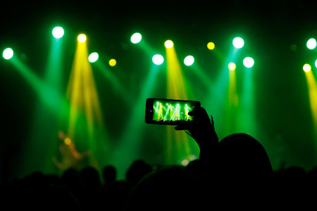 Making photo with smartphone during a concert to share the moment with friends on social networks