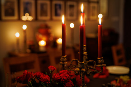 Vibrant red candles burning atop elegant holders in a vintage roomの写真素材
