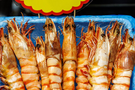 Vibrantly colorful and fresh shrimp carefully arranged in an appealing display for sale at a seafood marketの写真素材