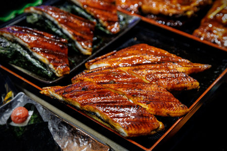 Enjoy the rich flavor of grilled eel, glazed and served on traditional plates for an exquisite dining experienceの写真素材