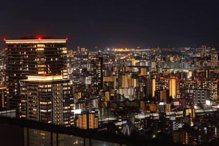 A captivating Osaka cityscape beautifully illuminated at night, dazzling skyscrapers and vibrant urban lightsの写真素材