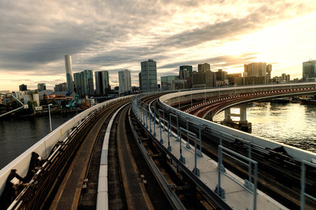 Tokyo monorail moving. City skyline at sunset, beautifully captured from an elevated railway trackの写真素材