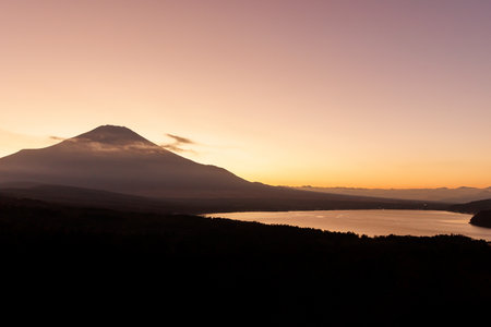 Witness the Majestic Sunrise illuminating the Fuji Mountain near the Calm Lakes shores.の写真素材