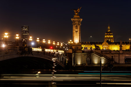 A city at night with a bridge and a tall building in the background. The lights on the bridgeの写真素材