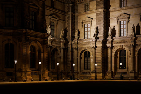 A large building with many windows and a courtyard. The courtyard is lit up by several lightsの写真素材