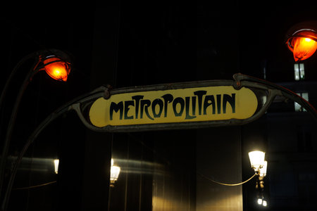 A yellow sign with the word Metropolitain written on it. Metro sign in Paris at the entrance to a station.の写真素材