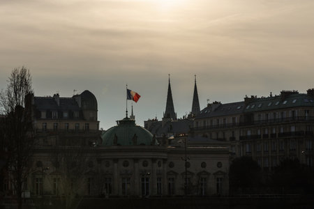 the French flag waving in the wind over the building in Parisの写真素材