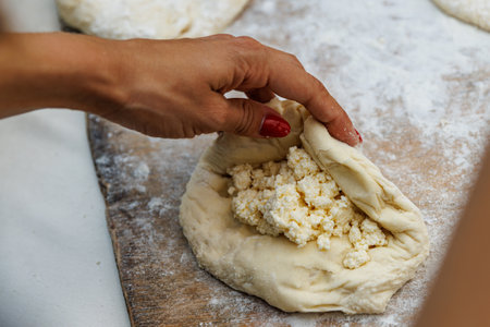 Putting cottage cheese into the doughの写真素材