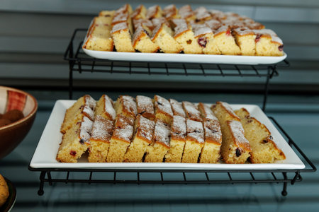 A tray of delicious-looking pastries with powdered sugar sprinkled on topの写真素材