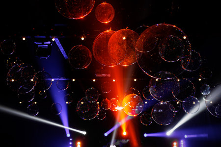 A stage with lights and a large number of colorful different sizes bubbles.