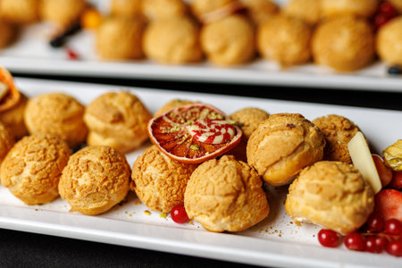 Close-up of Cream Puffs on White Plates with Garnish.