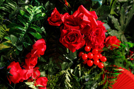 Artificial red roses and green leaves for decorationの写真素材