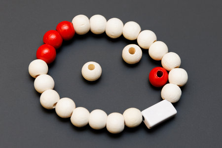 Red and white painted wooden beads on black backgroundの写真素材