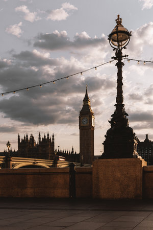 Close-up of ornate Thames Embankment lamp with Big Ben and Westminster Bridge visible behind under evening skyの写真素材