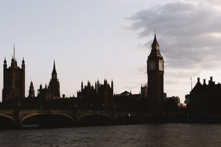 The famous clock tower and Houses of Parliament stand against a calm evening sky over the River Thames.の写真素材