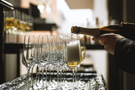 Multiple flute glasses filled with champagne arranged in rows for serving during a festive event.の写真素材