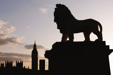Silhouette of the South Bank lion statue overlooking Elizabeth Tower and the Westminster skyline at sunset. Minimal shapes create a bold London icon.の写真素材