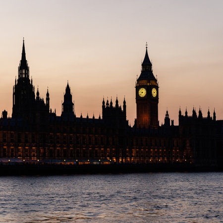 Sunset view of Big Ben and the Palace of Westminster glowing in warm orange light above the River Thames.の写真素材