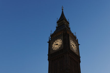 Big Ben clock tower photographed at twilight with deep blue sky and illuminated clock faces.