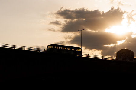 Silhouette bus crossing bridge at sunset in London