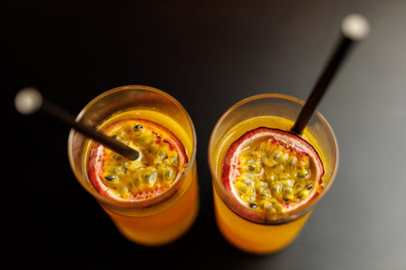 Top view of two bright yellow passion fruit beverages served with metal straws.の写真素材