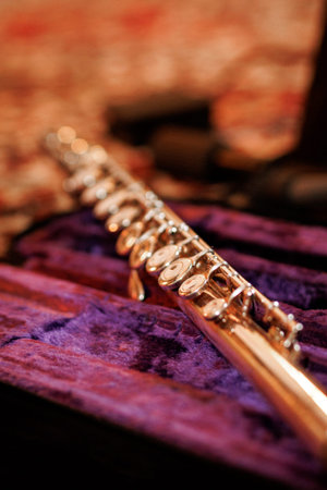 A silver flute rests in a soft purple velvet case with shallow depth of field highlighting the keys.の写真素材