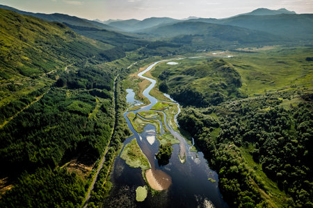 A high-angle perspective showing a blue river snaking through green forests and wetlands towards...