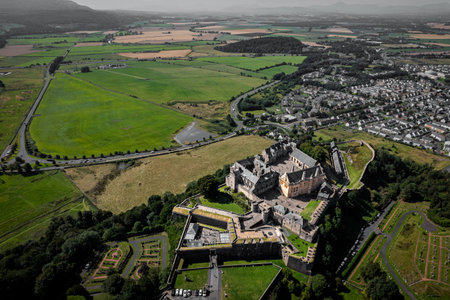 High angle aerial perspective of a massive stone fortress situated on a rocky outcrop. The historic...