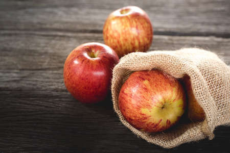 apples  in bag on wood backgroundの写真素材