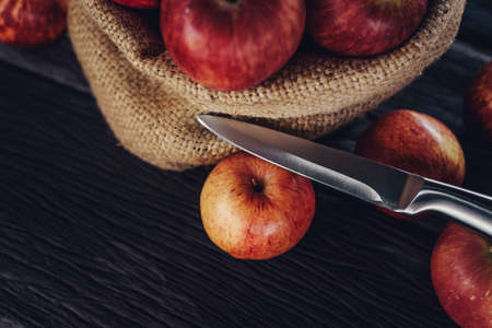 Apple in sack and knife on wood backgroundの写真素材