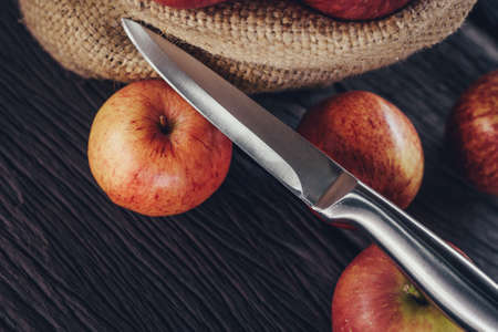 Apple in sack and knife on wood backgroundの写真素材