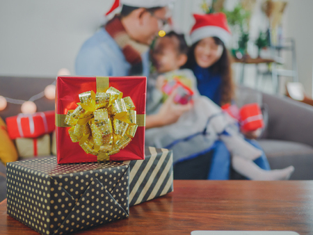 Three size colorful christmas gift box on wooden table blur family background.の写真素材