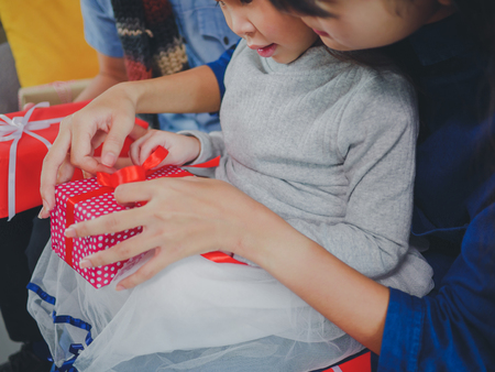 Asian young family on Christmas exchanging presents and enjoying their time together. Focus on the little girl.の写真素材