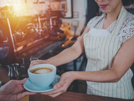 Young beautiful asian women barista giving coffee to customer at coffee shop, Cafe restaurant service concept,Owner small business concept.の写真素材
