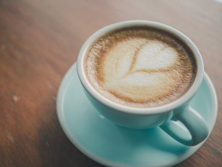 Coffee cup heart-shaped  on wooden table at bar counter Vintage color, filter effect.