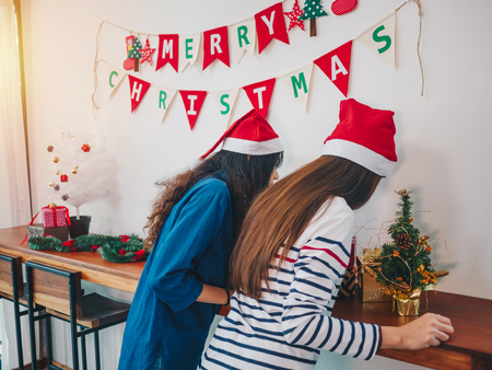 Two Asian women smiling take in Christmas party, Have Christmas Tree Ornaments.の写真素材