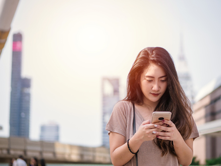 Young asian woman using smartphone searching for social media in the city.の写真素材