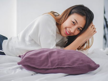 Young asian woman smiling happiness on the bed at home, Beautiful females looking at camera.