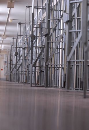 row of open jail cells or a cell block row of open jail cells or a cell block