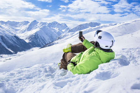 Happy successful man surfing mobile phone app at apine ski slope livigno italy resort village Happy successful man surfing mobile phone app at apine ski slope livigno italy resort village