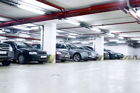 The shined underground garage with the moving cars and parked cars The shined underground garage with the moving cars and parked cars