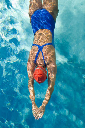 Athletic swimmer is diving in a swimming pool Athletic swimmer is diving in a swimming pool