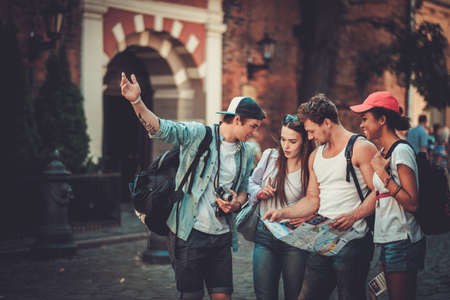 Multiracial friends tourists with map in an old city Multiracial friends tourists with map in an old city