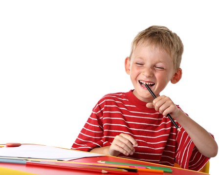 Laughing little boy with colored pencilsの写真素材