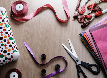 Colored felt, yarn, thread. Everything for handmade on the wooden table.