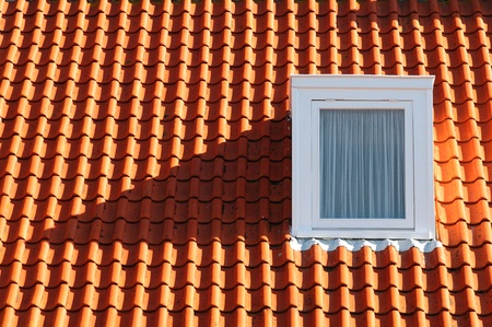 Red tile roof with a windowの写真素材